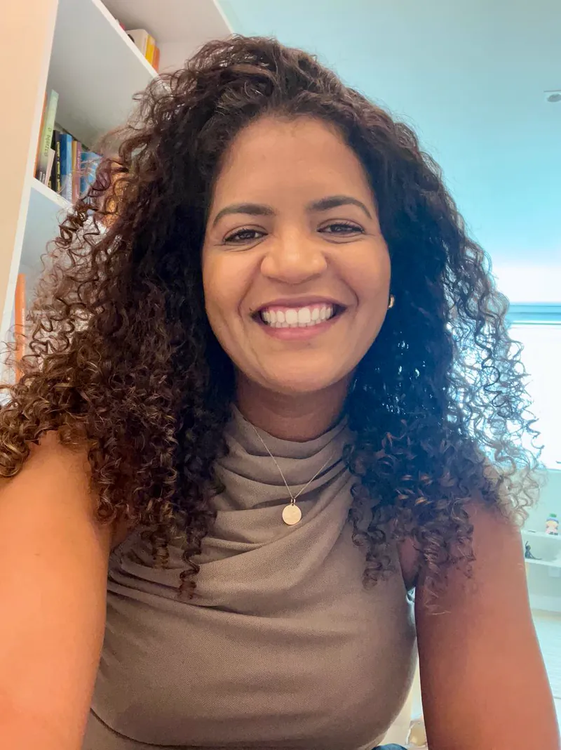 Psicóloga Patrícia Furtado sorrindo em seu consultório